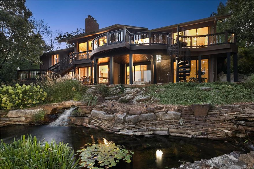 Nestled high atop a hill with sweeping, panoramic views, this home sits at one of St. Louis' highest points. It is an ultimate retreat for those who value nature and tranquility. Expansive composite decks overlook a custom koi pond with multiple waterfalls and giant boulders. Inside the house find vaulted, beamed ceilings, 4 BRs, 5BAs and over 4,900SF of living space. Indoor and outdoor space merge in an abundance of natural light. Eat-in kitchen features stainless, granite & oversize island. Great Room looks into a den/family room with FP and wet bar. Primary bedroom suite includes dual baths, one with steam shower, dual walk-in closets. 2nd en-suite bedroom on main. Above-grade walkout Lower Level w/2 BRs and bath and expansive recreation/entertaining rooms. Main level laundry. A long winding lighted driveway is a welcoming approach to the property, w/ aadtl off street parking. A long list of upgrades/improvements. Literally steps to Conway Park's dog park, pickleball, tennis etc.