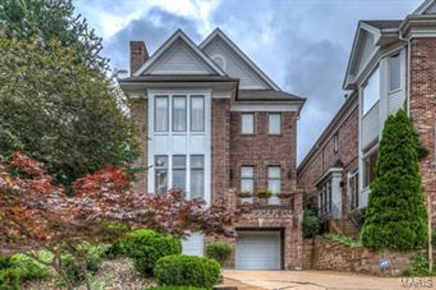 This classic side entry brick home artfully unites sophistication with a contemporary flair all within blocks of downtown Clayton. The dramatic 2 story entry greets you in style while the great room with its cozy fireplace, Bluestone accents, framed garden views and reading nook invite you in. Tray and coffered ceilings throughout provide architectural interest and ambient lighting. The kitchen includes breakfast bar, granite counters, SubZero fridge, new Jenn Air double ovens, range and dishwasher. A breakfast table fits perfectly in the bay window. Glass doors lead you to perennial gardens and a spacious deck. Upstairs are 3 en suite bedrooms, including a gracious master suite with a phenomenal walk in closet! Master bath has a granite floating double vanity, separate shower/Jacuzzi tub & skylight. Additionally, there is a family room and full bathroom in the lower level. A 3-car tandem garage completes the package with an abundance of storage.