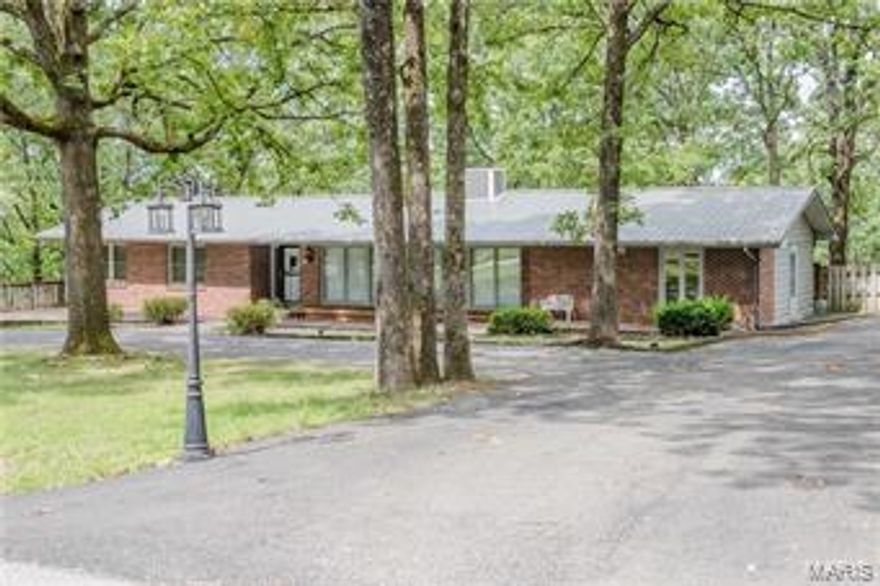 BEST LOCATION IN Waynesville/St. Robert!  This 4 bed, 2 bath Ranch style homes is located in one of the most ideal, established neighborhoods in the area. This spacious home has a huge circle driveway and front deck with built-in benches that can easily turn into planter boxes, BRAND NEW WOOD LAMINATE floors in the living room and bedrooms, new recessed lighting, a new metal roof less than 5 years old and a new A/C unit outside.  Inside you will find a gorgeous floor to ceiling fireplace and floor to ceiling windows in the living room.  HUGE kitchen that can accommodate a dining table or can be re-configured to suit your personal taste.  There are two living areas, one with built-in book shelves, Master Suite with dual vanities, a sun room with French Doors that leads to the deck and a HUGE fenced-in back yard. This home is completely move-in ready, however also has endless possibilities if its new owner is looking for a house to renovate!! Additional Rooms: Sun Room