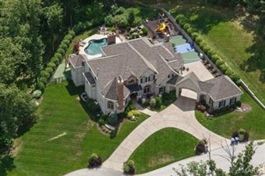 Luxurious Estate Home blended with Comfortable Family Living describes this Executive Masterpiece in the highly desirable Arbor Chase/Grand Meridien Neighborhood. Impeccable detail Throughout! Masterful Design features every amenity one could want. From the Grand 2sty Entry w/ sweeping staircase to the Library/Office with built-ins & fireplace to the Luxurious Master Suite w/ Sitting Room, Private deck and phenomenal bath, to the Ultra High-end Cooks Dream Kitchen & Fabulous Hearth Room featuring stone fireplace flanked by floor to ceiling book cases to the Elegant Great Room with wet bar to the 5 huge secondary bedrooms each w/ their own bath, to the 2 laundry rooms, to the unbelievable lower lever featuring a Theatre Room, Wine Cellar, Custom Bar, Bedroom, bonus play room, Family Room. Then walk out to your own private oasis of entertainment and fun! Pebble Tec Saltwater Pool, Putting Green, Spectacular Waterfall, Full Bar, Sport Court and Fire Place too.  THIS PLACE IS AWESOME!!!! Additional Rooms: Mud Room