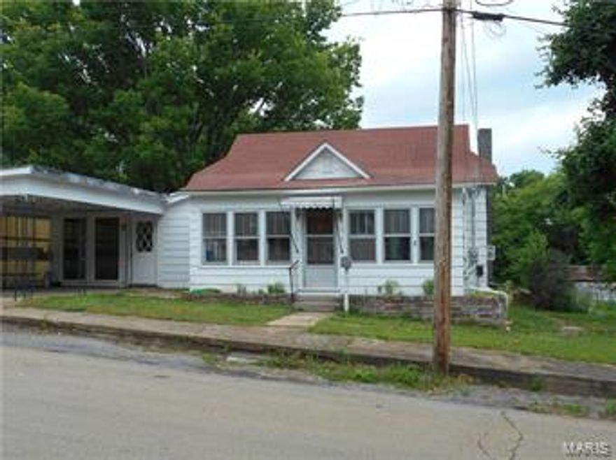 Gorgeous wood floors have been freshly refinished and stained to show original beauty! Kitchen has wood cabinets and newer vinyl flooring and an enclosed front porch too. Detached wood shop has covered concreted lean-to  area--perfect to sit and swing. Alley entrance and front parking!! This home has a lot more space than what it appears to have when you drive past.