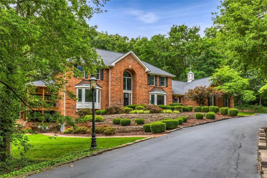 Exceptional full-brick 1.5 Sty situated on a wooded 1.8 ac lot adjacent to Sunset Country Club.  This custom-built Estate home features soaring ceilings, detailed trim work & oak hardwoods that extend throughout the main living area. 2-Sty marble foyer highlighted by dramatic curved staircase leads to formal dining room with wide bay window & vaulted great room with wet bar & floor-to-ceiling brick fireplace. Designer-inspired kitchen with quartz countertops, white cabinetry, stainless steel appliances & 8’ center island adjoins light-filled breakfast room. Coffered primary bedroom suite with luxury bath with freestanding tub offers an appealing retreat. The 2nd floor extends the living quarters with 4 additional bedrooms with Jack n’ Jill baths. Lower Level includes recreation room, family room with entertainment center, gathering bar, workout room & ½ bath. Extensively landscaped grounds with wrap around deck, brick patio, gazebo & hot tub plus direct access path to the Country Club.
