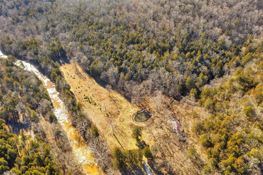 This beautiful property offers nearly 11 total acres with a small pond, natural spring, and a wet rock bottom creek that runs the entire length of the land! Complete with a concrete bridge over the creek, you’ll enjoy camping, hunting, and exploring this scenic land. Whether you’re riding a horse or a four-wheeler, you’ll have plenty of room to make memories. There is also a great home site at the top of the ridge with a gorgeous view of the property. Improvements including a gravel drive to the campsite, 2 concrete pads with steel metal pavilions, and electric service accessibility are icing on the cake. Both parcels are included in the sale - 10709 South Bridge Road and 10697 South Bridge Drive. Make memories you’ll never forget!