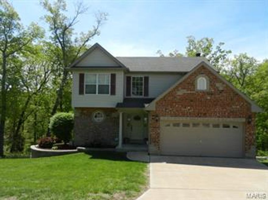 Former display home located on quiet Cul-de-sac street  , 4 bedrooms 3.5 baths Beautiful two story home with 2 story entry way , hardwood floors in kitchen and breakfast room, enjoy your morning coffee on the large  composite deck backing to woods , Master suite has coffered ceiling , walk in closet and whirlpool tub and separate shower double sinks  . 2 car garage with extra storage space  , full finished lower level with 4th bedroom and bath with heated floor. Family room with beverage fridge included  , brick and stone front . Just Minutes to Hwy 21 for easy commute.