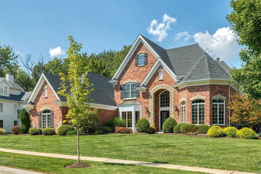 Beautifully designed brick & stone 1.5 Sty from award-winning Simon Homes. Travertine marble foyer highlighted by dramatic curved staircase leads to private study with beamed ceiling & custom built-ins, elegant dining room and stunning great room with architectural columns, soaring windows, wet bar & marble fireplace with Georgian mantel. Spacious open kitchen with granite countertops, 42” cherry cabinetry, 8’ center island & butler’s pantry adjoins breakfast room with convenient planning center & vaulted hearth room with floor-to-ceiling stone fireplace & bookcase. Coffered master bedroom suite with luxury bath with jetted tub offers an appealing retreat. Front & rear staircases access 3 additional bedrooms, 1 with ensuite bath & 2 with Jack n’ Jill bath. Builder-finished Lower Level includes recreation room with entertainment center, wet bar & brick fireplace plus workout room, office & full bath. French doors open to outdoor living room with full-height fireplace & grilling station.