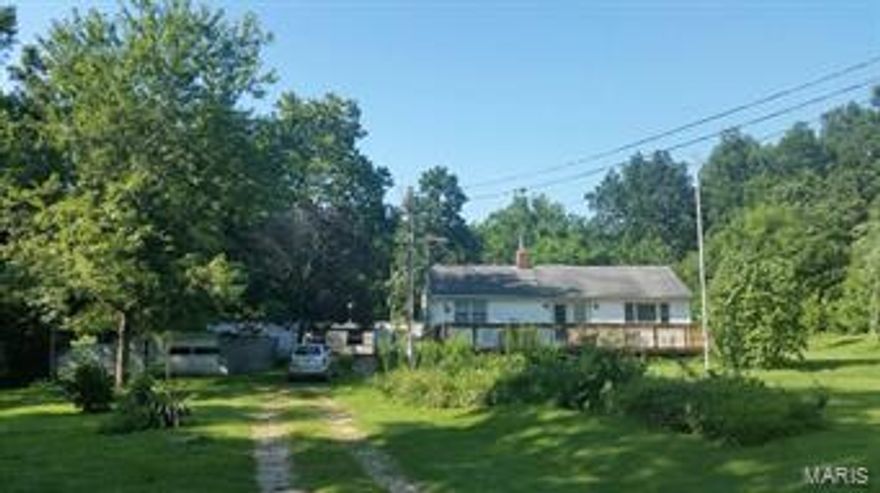 Perfect place to call home or have your own mini farm just outside of town.  Two bedroom two bath home with open floor plan.  Main level laundry is a plus and some remodeling completed in the 1980's.  Vinyl sided exterior, 3 outbuildings-one of which is a garage with automatic opener and storage for a mower or tractor, trailer in rear of property was used for storage and smaller shed as well.  Large deck off the front of the home is great for enjoying the evenings in the country.  All of this nestled on 2.8 acres.  Don't miss this unbelievable buy!