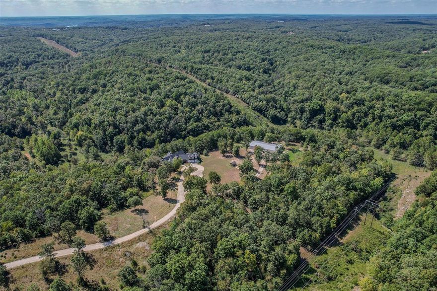 An iconic, once-in-a-lifetime kind of property! Nestled on 120 secluded acres, you’ll enter down a private road w/ a gated entrance. The completely renovated, massive Craftsman home is 8,602sf w/ vaulted & 10' ceilings on all 3 levels, 2 fireplaces, stained glass transoms, & 2x6 solid oak floors. The kitchen is a dream with so much space, new appliances, center island, & TONS of natural light. Master suite has 2 walk-in closets & all the amenities you’d expect. The finished bsmt features a beautiful wet bar, theater, fitness space, game room, 2 beds & a bath. A covered deck & lower patio spans entire length of the house. BRAND NEW roof, HVAC, all appliances, & fixtures. The 5,000sf detached shop bldg stores all the toys you could dream of, and it includes 1,300sf living space which would make the perfect in-law living quarters. Offers all the seclusion you’re looking for, the rustic elegance you crave, and it’s located just a stone’s throw from ALL that Lake of the Ozarks has to offer.