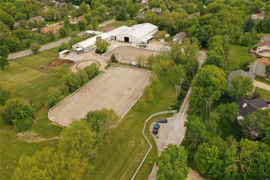 40 stall horse boarding/training barn on 8+ acres. Established and operating 30+ years, offering lessons, camp, training and boarding. Property is completely fenced w/gated entry. 3 arenas include 2 outdoor: 196’x 96’ dressage ring w/All-weather footing; 75’x160’ jumping ring w/lighting and covered viewing stand placed between rings; Indoor arena is 168’x65’ w/auto watering system, 2 bay doors, kick- boards surround & mirrors. 20 paddock/turnout areas 7 of them are grass pastures, round-pen. 3 wash stalls, 3 grooming stalls, covered farrier station, restroom w/laundry. Stalls are in 3 different 12’-15’ wide asphalt aisle-ways. 13 stalls have run-outs to dirt/chat paddocks. Majority of stalls are 12’x12’ or 11’x14’ with 1 breeding stall. 3 tack rooms w/lockers, 38+ saddle & 40+ bridle racks. Hay delivery is easy w/sep drive to back of property & storage for 500 bales. Office has viewing window. 2 bed 2 bath home w/vaulted sunroom addition, large mud room, covered porch & fenced yard.