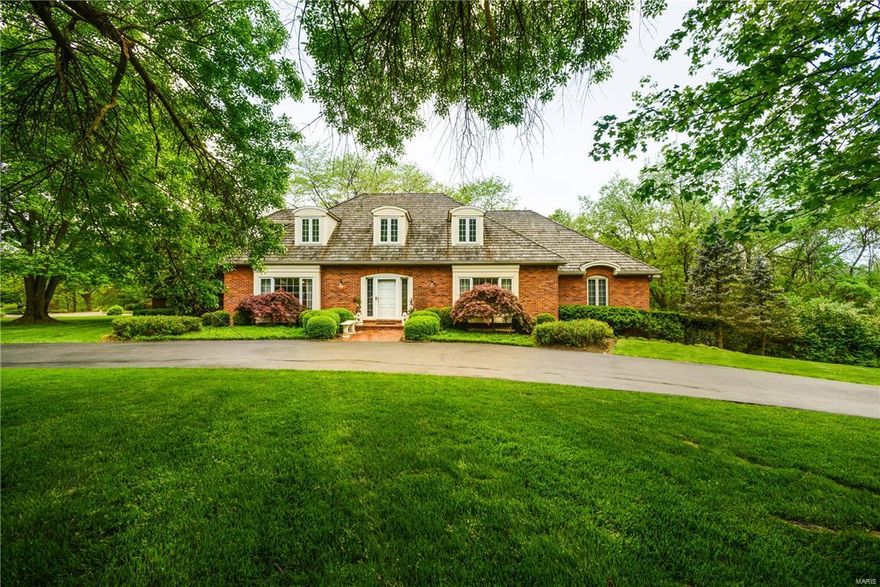 Enjoy this spacious private shake roof home on one acre lot with immediate access to Queeny Park! The best of both worlds with traditional separate dining and living spaces combined with open floor plan kitchen, breakfast room and sun room adjoining vaulted family room with cozy fireplace and built-in bookcases. Main floor master suite wing with two ensuite bathrooms, separate closets and pocket door to paneled study. Upstairs, three bedrooms, bonus room and hallway full bath. One bedroom includes ensuite bath ideal for guests. Large walk-out lower level with custom bar and media space, fifth bedroom and full bath. Beautiful architectural detailing showcased in vaulted, tray, and coffered ceilings, bead boards, panelling, and various built-in shelving. Great entertaining in lush wooded pool and hot tub setting with brick patios! Additional Rooms: Mud Room, Sun Room