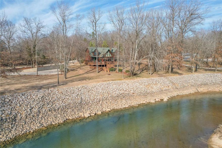 Welcome to your secluded paradise on Current River! Nestled on 6 acres of park-like setting, this stunning log cabin is only 1 mile from town with no gravel road. This spacious cabin boasts 4 bedrooms and 2.5 bathrooms, with a large basement garage providing ample space for vehicles and storage. The home features granite countertops, hardwood floors, and a captivating deer antler chandelier accentuating the living room's fireplace. Step outside to the expansive deck that wraps around the front of the home, offering breathtaking views of the river. The interior is adorned with logs, enhancing the rustic charm of the cabin. Enjoy riverfront living with your very own private beach and boat ramp. Host gatherings at the outdoor pavilion, perfect for entertaining guests or simply relaxing in nature's embrace. Don't miss this rare opportunity to own a piece of paradise on the Current River. Schedule your showing today!