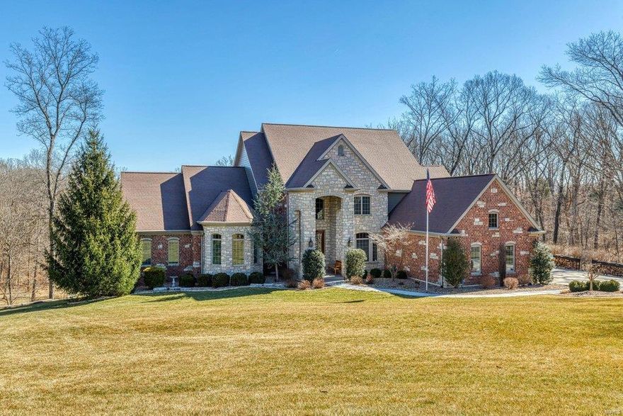 Stunning brick & stone 1.5-Sty with over 9400 sf of living space enhanced by hand-honed maple flooring, soaring ceilings & arched entryways. 2-sty hardwood foyer leads to private study, elegant dining room & spectacular great room with wet bar, floor-to-ceiling stone fireplace flanked by built-in bookcases & dramatic wall of windows. Designer kitchen with 42” cherry cabinetry, granite countertops & Jenn-Air appliances adjoins light-filled breakfast room & vaulted hearth room with wood stove & French doors that open to screened porch. Coffered master bedroom suite radiates warmth with a direct vent fireplace, sitting area & beautifully appointed bath with shower spa. The 2nd floor extends the living quarters with 3 additional bedrooms, 1 with ensuite bath & 2 with Jack n’ Jill bath, & bonus room. Lower Level includes recreation room with fireplace, gathering bar, game room & media room plus work out room, 5th bedroom & full bath. Situated on a 3.2-ac lot with patio & resort style pool.