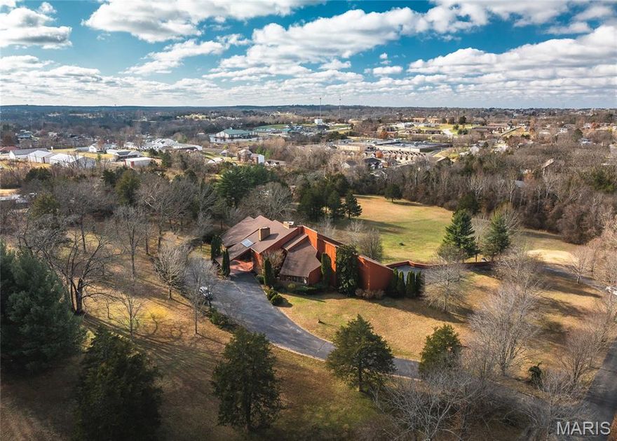 Live in Luxury on a Secluded 6.27 m/l Acre Estate!

Featuring an architecturally distinctive design with a curved, window-clad facade, this one-of-a-kind home offers an abundance of natural light and scenic views. Set amid mature trees and lush landscaping, the property provides a tranquil and private setting.

Indulge in the luxury of space and light in the expansive living area, where a wall of windows floods the room with natural sunlight, creating a bright and inviting atmosphere.

With approximately 13,000 m/l sq ft of living space, this exceptional residence boasts 6 bedrooms, 6.5 bathrooms, and three fireplaces. Highlights include two great rooms, two kitchens, a formal step-up dining room, sunroom, two offices, workout room, and two wine cellars.

The main-level master suite impresses with vaulted 20-foot ceilings, two walk-in closets, and a private patio overlooking the expansive grounds. The gourmet kitchen overlooks an enclosed courtyard with a mature tree, adding to the home’s charm.

Additional features include a detached garage, brand new roof, and fiber optic broadband — all within the desirable Rolla School District. This secluded estate offers endless potential for customization and luxury living in a rare, prestigious setting.