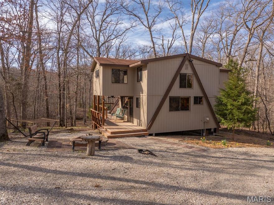 As you turn into the drive the transition is immediate. The business of life gives way to a quiet, wooded setting where the pace naturally slows. A circular driveway opens to a firepit area with hammock already in place. Just beyond is the inviting covered front porch. Inside, the chalet has been fully updated offering the fun cabin vibe. The vaulted living room makes an immediate impression, anchored by expansive walls of glass. The remodeled kitchen features updated cabintry, counters, and a stylish backsplash. There's plenty of space for meal prep! Tongue-and-groove cedar ceilings carry throughout tying each room together with a consistent finish. The main-level primary bedroom is positioned for convenience with direct bath access and large windows. Two additional bedrooms offer flexible sleeping arrangements, easily accommodating bunk rooms or queen setups. The open loft adds valuable square footage that's well suited for a gaming/movies, workspace, or additional sleeping. High-speed fiber optic internet is available making remote work and streaming simple and reliable. 
Out back, the deck extends the living space into the trees, offering ample room for dining, grilling, or simply sitting back and taking in the surroundings. The exterior has been professionally finished with Rhino Shield and includes remaining warranty coverage. A separate storage shed provides space for tools, lake gear, or a golf cart. A private trail leads through the woods to the common area dam at Wunderbar Lake. Such a great spot for fishing, launching a kayak, or enjoying a quiet stretch of water. Larger lakes, including Lake St. Gallen and Aspen Lake, are just minutes away with boat launches and community beaches. This property can be a short term rental if desired. Impeccably maintained and thoughtfully cared for this property is ready for immediate enjoyment within the Innsbrook community.