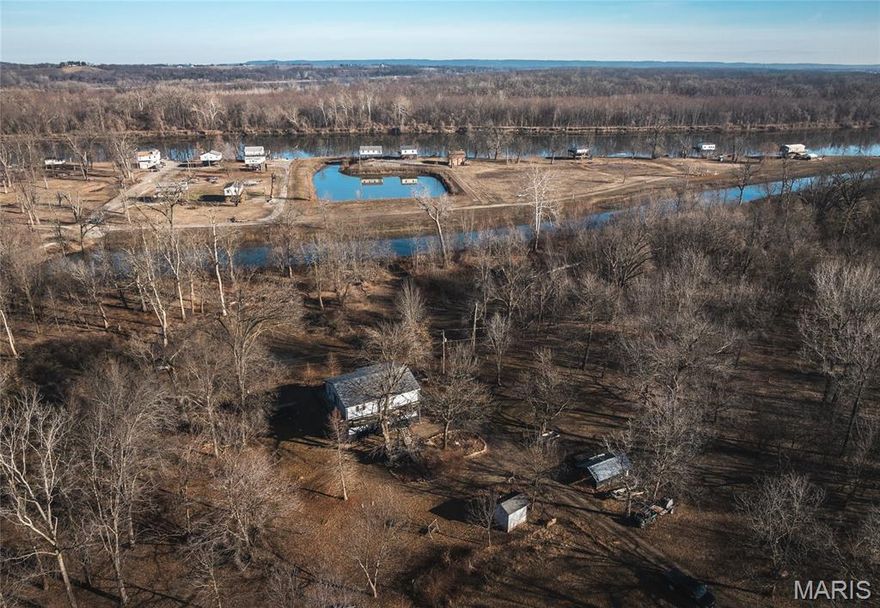 Discover a rare opportunity to own a stunning Mississippi River bottom retreat just minutes from St. Charles.  Located only three miles from town, this exceptional property offers the perfect balance of peaceful seclusion and convenient access  ideal for a weekend getaway, full-time residence, or homesteading dream. This charming 3-bedroom home features expansive wrap-around decks, Imagine morning coffee overlooking the water and evenings watching wildlife from the comfort of your own deck, Included is an additional riverfront lot complete with a private dock and boat slip, giving you direct access to incredible fishing and endless days on the water. With river frontage, you'll enjoy some of the area's best fishing and excellent hunting opportunities, including abundant deer population, The land itself is truly unbelievable. Nestled in the rich, fertile Mississippi River bottom soil, this property produces extraordinary gardens year after year. Already established are tame blackberries, asparagus beds, mature pecan trees and a variety of other thriving plantings. Whether you're dreaming of gardening, hobby farming, or full homesteading, the soil quality here is second to none you truly have to see the produce to believe it. Properties like this offering river access additional buildable lot, established perennial plantings, prime hunting, exceptional fishing, and close proximity to town rarely come available at such an attractive price. If you've been searching for a getaway property on the river with unmatched natural beauty and productivity, this is your chance.