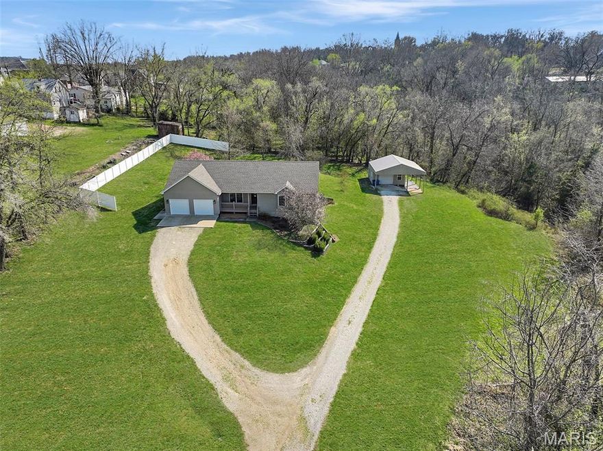 Hard-to-find 2.5-acre property inside the city limits offering a beautifully maintained one-owner ranch with space to live, work, and entertain! This well-cared-for home features 3 bedrooms and 3 baths, highlighted by hardwood floors, vaulted ceilings in the great room, and a separate dining area perfect for gatherings. A masonry gas fireplace anchors the great room, creating a warm and inviting focal point. The kitchen is designed for both function and style with custom maple cabinetry, a center island, and a built-in desk area. The hall bath includes an onyx shower, while the spacious primary suite offers a walk-in closet with shelving and a private bath featuring a jetted tub, double vanity, and separate shower. The walk-out lower level adds valuable living space with a large family/rec room, third bath with fiberglass shower, and a convenient kitchenette complete with refrigerator, gas stove, and sink, ideal for guests or multi-generational living. Additional highlights include a 2-car attached garage, central vacuum system, and a 20.5 x 20.5 detached outbuilding with lean-to—perfect for a workshop, hobbies, or extra storage. Enjoy the rare blend of acreage and in-town convenience. All kitchen appliances stay, including three refrigerators and a chest freezer. Don't miss your opportunity to make this one yours!