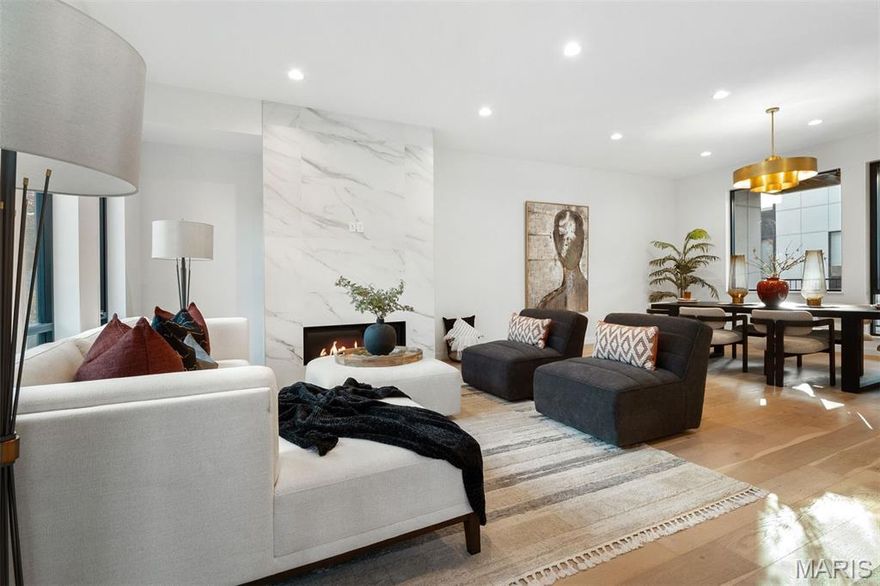 Luxury new construction. Exquisite finishes. Now offered at a remarkable price. Crafted for elevated urban living, this sophisticated residence unfolds in a wash of natural light—where 10' ceilings, wide-plank wood floors, expansive picture windows, and curated designer lighting create a sense of quiet refinement. The living and dining spaces gather gracefully around a striking gas fireplace, wrapped in floor-to-ceiling custom tile—both sculptural and warm. The kitchen is a true centerpiece, appointed with Bertazzoni appliances, an expansive quartz island, custom Beck Allen Cabinetry, gas cooktop, and a built-in pantry. It opens seamlessly to a private 12x14 terrace—an inviting extension of the home, complete with gas hookup for open-air dining beneath the sky. A thoughtfully placed laundry and powder room complete this level. Upstairs, the primary suite offers a serene retreat, with a generous walk-in closet and a spa-inspired bath featuring a floating vanity, dual sinks, a beautifully tiled shower with frameless glass, and a deep soaking tub designed for lingering. Two additional bedrooms and a full bath provide comfort and flexibility, while a beverage center and wet bar lead to a second private terrace—perfect for slow mornings or evening unwinds. The lower level reveals a versatile den or office, an additional full bath, and a rare three-car garage—offering both function and ease. Set within a thoughtfully designed community with lush professional landscaping, an eco-conscious drive court, and a dedicated dog exercise/relief area, this home is perfectly positioned in the heart of the Central West End—just moments from beloved dining, culture, universities, and medical centers. A refined, soulful alternative to condo living—where style, space, and serenity meet.