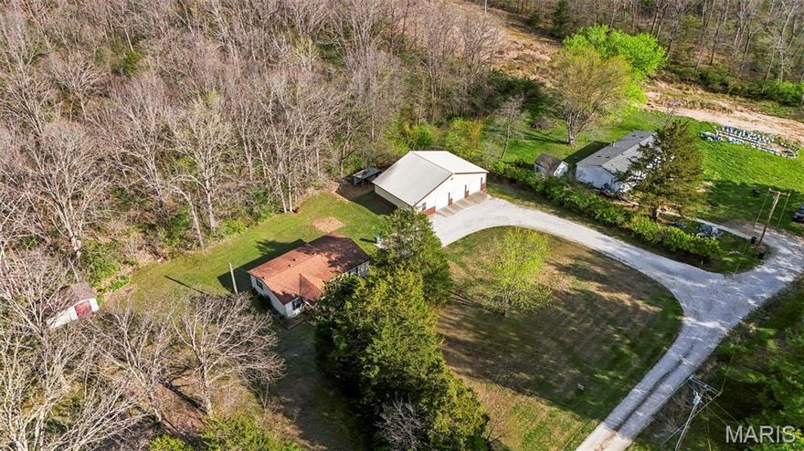 Don't miss this well-maintained one owner property with 50 x 31 garage on 5 acres in Winfield! This double wide mobile home offers hardiboard siding and architectural shingle roof! Laminate flooring through much of the home, with tile floors in the kitchen and breakfast area. Large great room with vault and ceiling fan. Kitchen offers stainless appliances, with oven and dishwasher just 6 months old! Both kitchen and dining area also offer vaulted ceilings! Laundry is just off kitchen area. Walk out kitchen area to large backyard and private woods! Split bedroom plan with large primary bedroom with vaulted ceiling and fan and vaulted private bath. Two additional bedrooms and full bath on the opposite side of the home. Amazing 50'x31' garage with room for your cars, your trucks, your mowers, your side-by-side, your toys and anything else you want to store here! 200 amp service, metered separately, lots of great lighting and 10' ceilings! Additional features include small shed, and lean to that can be used in various ways, including chickens! Tons of space for gardening, playing in the flat level yard, making trails in the woods and so much more!