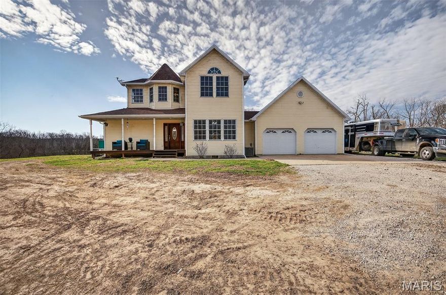 Set beyond the ordinary & immersed in the quiet rhythm of the countryside, this remarkable property invites you to experience a lifestyle where comfort, function, and natural beauty converge in perfect harmony. From the very moment you turn onto the gravel drive, you begin to sense that this is more than just a home-it is an entire way of life. As the drive opens up, a striking 100 x 200 horse arena comes into view, setting the tone for the equestrian possibilities that define this land & welcome riders, trainers & enthusiasts alike into a space designed for both performance & enjoyment. Beyond the arena, the cheerful yellow two-story home stands radiating charm & practicality in equal measure. Its exterior color hints at the light-filled interior waiting inside, where oiled wood floors greet you with a natural warmth that immediately feels like home.The living room, newly carpeted, provides a cozy retreat for quiet evenings, family gatherings, or simply unwinding after a day spent outdoors. 
Overlooking the property, the kitchen allows you to stay connected to the land as you prepare meals, whether you are watching horses graze, monitoring daily farm activities, or simply enjoying the ever-changing scenery. Equipped with a gas cooktop, ample counter space, & a tasteful tile backsplash, the kitchen is designed to accommodate everything from casual breakfasts to elaborate dinners. 
The main floor continues to impress with its thoughtful layout, including a mudroom off of the covered deck that serves as the perfect transition space between the outdoors & indoors. Whether returning from the barn, the fields, or a walk along the property, this area helps keep the home organized & clean.Adjacent to the garage is a separate laundry space, complete with a wash sink. A full bedroom on the main level offers flexibility, ideal for guests, multi-generational living, or even a home office. Nearby, the hall bathroom features a soaking tub that invites relaxation, offering a peaceful retreat at the end of a long day.Upstairs, the primary suite is a true sanctuary, designed to provide a restful escape from the demands of daily life. With its spacious layout, walk-in closet, & beautifully appointed en-suite bathroom, a newly tiled shower & a double bowl vanity, ensuring both style & convenience. A second bedroom upstairs also boasts its own en-suite bathroom with a tub/shower combination. Additionally, the inclusion of a Generac generator offers peace of mind, ensuring that the home remains powered even during unexpected outages.The well system is equipped with an industrial pump capable of servicing the entire property, including strategically placed spigots throughout the farm.
The inclusion of 12 x 20 runs with split panels offers further flexibility, allowing for the separation of horses as needed. Within the barn, a 12 x 13 interior stall is outfitted with built-in feeder & hay storage, ensuring that essential resources are always within reach. A cattle sweep & full working corral provide the necessary infrastructure for handling livestock efficiently. The presence of a workshop adds another layer of utility, offering a dedicated space for repairs and maintenance tasks. The land itself is a defining feature of this offering. Additional cattle ponds and wet-weather creeks enhance the property’s natural appeal. The terrain is thoughtfully balanced, with approximately 60 percent open fields and 40 percent wooded areas, creating a dynamic environment that caters to a variety of uses. The wooded sections are rich with mature walnut and oak trees, providing shade, beauty, and potential value. Bordering Mark Twain land, the property benefits from an added layer of privacy and natural beauty, with protected surroundings that enhance its long-term appeal. In a world where convenience often comes at the expense of character, this property stands as a rare exception, offering both modern amenities and timeless appeal. Roof is 1 year old!