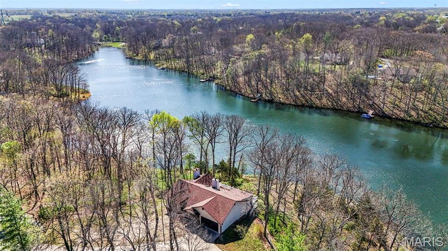 Live every day like you’re on vacation—this is your opportunity.

Exceptional waterfront ranch with stunning views set on a 14-acre lake, featuring nearly 1,000 feet of shoreline and over 10 private, wooded acres with walking trails. This fully renovated home has been updated from top to bottom.

Find gorgeous hand-scraped hickory flooring flowing from the foyer through the vaulted great room, complete with skylights and wood-burning stone fireplace. The open layout leads into a bright breakfast room and an updated kitchen with upgraded cabinetry, stainless steel appliances, tile flooring, and solid stone countertops.

Off the kitchen, a beautiful 17x9 sunroom addition offers a tongue-and-groove vaulted wood ceiling and panoramic views of the wooded property and lake—perfect for relaxing year-round with climate control.

The layout of the home offers spacious primary suite featuring a second fireplace and a luxurious en-suite bath with tile flooring, whirlpool tub, double vanities, and a separate shower. Two additional bedrooms and a fully remodeled bath complete the main level.

The walkout lower level adds even more living space with a fourth bedroom, full bath, laundry room, and ample unfinished space ready for your customization.

Outside, enjoy an expansive composite deck overlooking the water—ideal for entertaining or quiet evenings by the lake.

Additional updates include a new roof (2023), deck (2006), concrete driveway, and siding (2006). Tucked at the end of a cul-de-sac, the property also features a picturesque waterfall and creek, with Indian Camp Creek just a short walk away.

A rare opportunity to own a private waterfront retreat in a truly serene setting.
