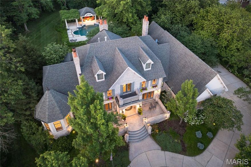 Uncompromising Executive home sitting high above the lane with commanding and distinguished presence that continues to inspire as a statement of excellence for all 18 years since its inception. This statement in opulence epitomizes perfection in size, with 7700 SF total living area, exotic grounds, design and finishes, making any direct comparisons ineffective. Situated on over an acre, the setting is enveloped in refined gardens and landscape; a resort quality pool and fountains, pergolas and patios. Grounds are lined with mature trees creating a veritable park-like sanctuary for those who require a secluded and private lifestyle. A majestic circle drive connotes sophistication and elegance. Entry through wrought iron doors leads to the 2-story foyer and sweeping staircase. Hallmarks of the main level include a mahogany office/den with boxed ceiling and fireplace. The Great Room is engulfed in natural light and enjoys a full bar. The Dining room, crafted with French Doors and coffered ceiling, seats over 10.  Find an extravagantly sized kitchen with vault ceiling and adjacent Hearth & Breakfast Rooms that open to patios and pool. A Main level Primary Suite is detailed in marble at its fireplace and luxe bath floor, with room size multi-unit shower and jet tub. 3 en-suite bedrooms and office on 2nd Level. Fully finished Lower Level offers media, recreation & billiard rooms, 2-sleeping areas and temperature controlled wine room. Laundry on Main; 4-car garage.