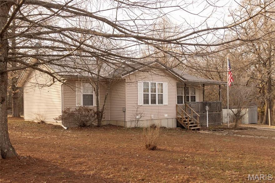 Welcome home to this beautifully maintained 3 bedroom, 1 bath cottage-style home offering the perfect blend of country charm and convenience — located on the edge of town with peaceful county surroundings. Step inside to open living spaces filled with warmth and character, featuring luxury vinyl flooring, a cozy propane fireplace, and a highly efficient heat pump with updated HVAC. The kitchen offers a charming propane cookstove and an eat-at breakfast bar, perfect for casual meals, morning coffee, or gathering with family and friends, all while maintaining the home’s inviting cottage feel.
 The primary bedroom includes his and hers closets, providing ample storage. Outside, enjoy both a covered front porch and a covered back deck, perfect for morning coffee or evening sunsets. A carport adds convenience and protection for your vehicle. Situated on 2.5 acres, this property offers room to breathe — complete with gardening spaces, your own private well, and plenty of space for family pets or small livestock. In addition to the home, you’ll love the unattached metal shop, offering dedicated workspace and plenty of room for vehicles, equipment, or hobby projects. Whether you need storage, a workshop, or extra covered parking, this versatile building adds incredible value and functionality. With a durable metal roof and thoughtful updates throughout, this one-owner home has been lovingly cared for and is ready for its next chapter. Whether you're dreaming of a hobby farm, peaceful retreat, or simply more room to roam, this property delivers.