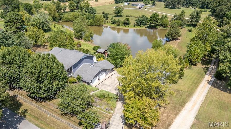 This is a one of a kind property. This can be a multi-family home, a single family home or an amazing vacation rental. Take your pick. There are 3 separate living areas. Two on the main level and one on the upper level. 2 full kitchens. One on the upper level and one in the main level, and a mini kitchen in the garage of the main level. 2 car attached garage and a 3 car detached garage with workshop area. This property also features a large pond with outbuilding overlooking and a bridge/dock area. There is a full time goose resident with its own living quarters in the pond. 2 gazebos overlooking the pond. This home has so many custom features, inlayed tile floors throughout the main level, custom exterior and security doors, one of a kind primary suite with walk-in shower and soaking tub, built-in cabinetry, solid wood interior doors, custom kitchen and so much more. There is also an elevator that makes this home handicap assessable. This home is beautiful the way it is, but could use some work and finishing touches, and is priced accordingly. Don't miss out on this spectacular property