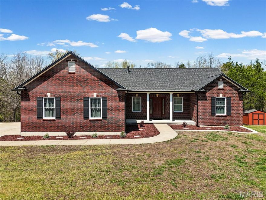 Custom-built 4 bed, 3 bath ranch situated on 5 scenic acres, offering the perfect blend of privacy and functionality. This meticulously maintained home boasts exceptional curb appeal with a full brick front, side-entry garage, extended parking, and a welcoming covered front porch. Inside, you’ll find an open floor plan with 9’ ceilings, built-in bookshelves, and a cozy gas fireplace. The main level features convenient laundry, two bedrooms, and a flexible third bedroom or formal dining space to suit your needs. The kitchen is beautifully appointed with stainless steel appliances, custom cabinetry with crown molding, and a breakfast bar. The adjoining breakfast room walks out to a private deck overlooking the peaceful backyard and surrounding woods—ideal for relaxing or entertaining. The spacious primary suite offers a large walk-in closet and an en-suite bath with a walk-in shower. The partially finished walkout lower level expands your living space with a generous family/rec area, separate sleeping area, third full bath, and ample storage. The 5-acre property includes approximately 2+ acres of level, cleared ground, with the remainder wooded for added privacy and natural beauty.