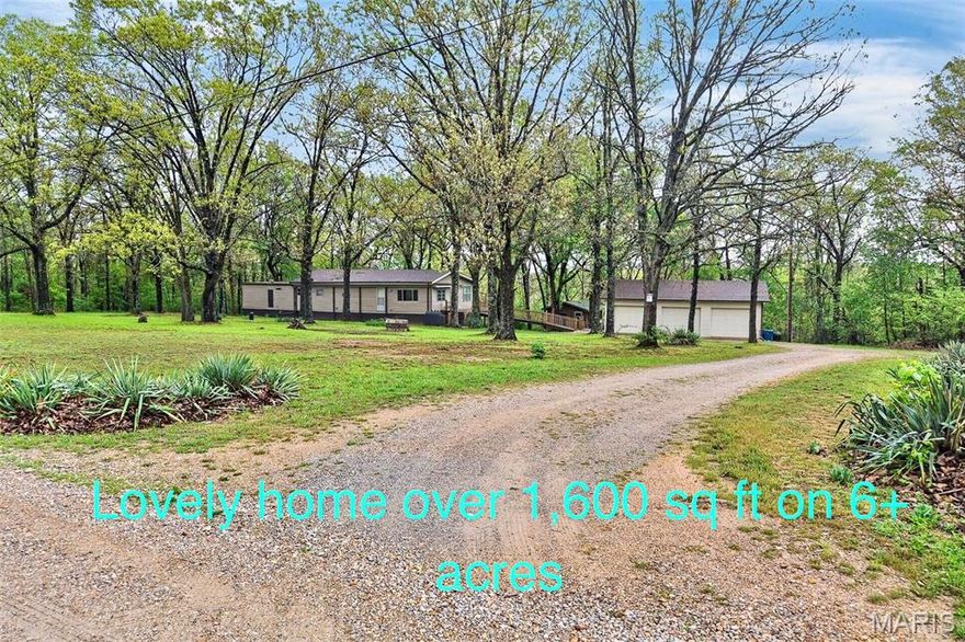 This home consists of a mobile with an addition on a concrete foundation, nestled away from the road in a BEAUTIFUL PARK-LIKE SETTING ON 6.01!! Including the addition to the original homesite, it now offers over 1,600 sq ft of living space! The layout consists of a 3-bedroom, 2-bath, a spacious living room, and a beautiful updated kitchen that includes stainless steel appliances, plenty of cabinetry,  and a combo dining room, PLUS a lovely 4-season sunroom with a built-in bench, A DETACHED 3-CAR GARAGE, and a LOVELY OFFICE/ CABIN great for your guest! with utilities including septic ( needs a few finishing touches), ALSO a man cave /She-shed with propane heat, water, and electric. YOU WILL LOVE THE UPGRADES, including a newer roof with a transferable warranty, a wrap-around deck with a ramp, updated LED lighting, sinks and faucets,  kitchen countertops,  2 additional connections for the laundry are available (currently the 3rd bedroom is being used as a laundry area), and it could be moved. dusk-to- dawn security lights, newer siding at the front of the home, easy-to-clean/remove vinyl wallpaper, newer LVP flooring throughout the home, and numerous hydrants throughout the property. Enjoy the beautiful setting. This property is located about 600 ft from the Bennett Spring Conservation Area, which is home to abundant wildlife. Then enjoy hiking, hunting, camping, and trout fishing down the road at Bennett Spring Park. You will love this property.