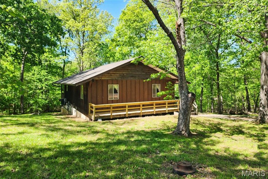 SELLER saying GOODBYE to their family retreat with ownership since 1979.  All electric three bedroom, two bath home nestled in a wooded setting in a residence only community of Miramiguoa Village/Park. The breathtaking views, tranquil feel and friendly folks will capture your spirit.  A welcoming community entrance begins your journey to the property. When you go see the property you will find there are three For SALE signs - these signs designate all the parcels sold with the sale of house.  I used to signs for an easy visual. Pull into the driveway and prepare yourself. There are two entrances to the home; off the back deck or the side entrance off the front porch  Walk-in to the carpeted open concept living room with coat closet, large picture windows and sliding door leading to deck. Kitchen is perfect size with wood cabinetry, lots of counter space, double sink and appliances to stay with sale. There is a man door from kitchen leading to the deck and to the lower level basement. Hallway leads to all three bedrooms with wall to wall closets, a full hallway bath and linen closet. Primary bedroom has his and her closets and a primary bath. Lower level walkout to the garage has laundry area, storage shelving and is wide open area. Exterior boasts large driveway leading to garage, a large 20X10  wood deck on the back of the home with bench seating, a porch that wraps the entry side of the home, a carport/concrete entertaining slab and gorgeous landscape of wooded grounds which allow deer and other wildlife the frolic about. There are three parcels and 11 lots which will come with the sale.  A monthly fee of $81.00 paid which covers, road maintenance, water and trash. The Miramiguoa community is serviced by a community well and the home has a private septic system which has been maintained by Central Missouri Septic System. Newer Roof 2021, Newer HVAC System 2009. The furnishings in the home are part of the sale EVERYTHING. 
There are several parcels which have lots associated with the parcels that will be provided with the sale and come with the sale/house sale which will be quit claimed at closing to the buyer and come with the house: When you go see the property you will find there are three For SALE signs - these signs designate all the parcels sold with the sale of house. I used to signs for an easy visual 
- Parcel # 34-3-060-1-001-115000  (HOUSE) House lots are 237 - 241 (4 lots) 
- Parcel # 34-3-060-1-002-114000 (DRIVEWAY) Lots are 232-236 (4 lots)
- Parcel #34-3-060-1-002-113000 (LOWER LOTS)  Lots are 228 - 231   (3 lots)