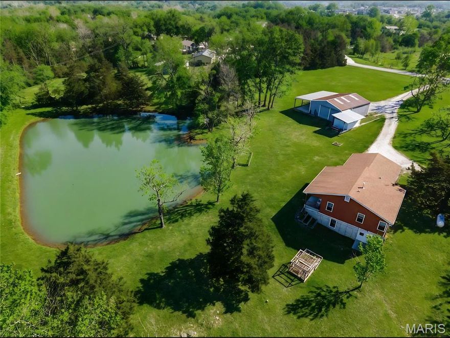 5.1 rolling acres in the heart of Wentzville; this rare "country-in-the-city" property blends space, privacy, & practicality. This 2 bed, 2 bath home offers 900 square feet with main floor laundry, wheelchair accessibility and a walkout basement that is ready for whatever you envision next. Outside, it only gets better: a stocked 1-acre pond, pasture and woods, plus a large outbuilding with a full bath that is perfect for cleaning up after a day on the farm - plus the RV storage area. The private well delivers excellent water, the property also has fencing around the perimeter for additional flexibility and convenience. Located within sought-after Peine Ridge and North Point schools, this is country living and city convenience. Light restrictions keep your investment protected (permanent structures only; no subdividing), while still giving you room to breathe, build and enjoy. In short: space to roam, water to enjoy AND just enough rules to keep the neighbors honest.