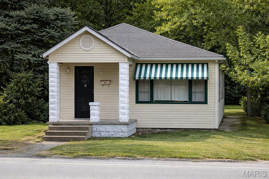 Bungalow-style home featuring a front yard and a porch