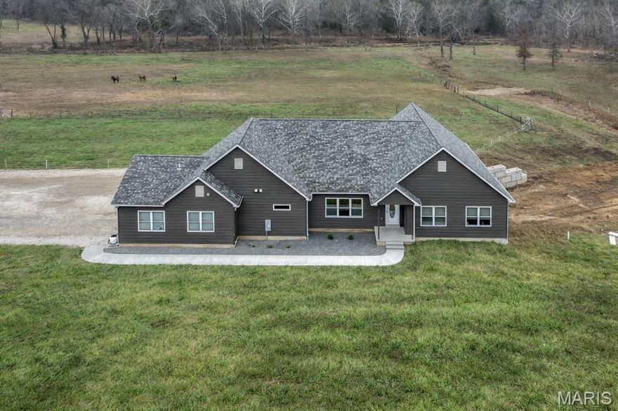 Set on approximately 6.75 acres, this custom-built 2,700 sq ft home is just 5 years old and thoughtfully designed for country living with all the modern comforts. If you’ve been dreaming of space for horses, cattle, or other livestock... this one is ready. Inside: An open floor plan with vaulted ceilings creates a bright, welcoming feel. The chef’s kitchen flows seamlessly into the main living area, making it perfect for gathering. The spacious primary suite offers private deck access... ideal for slow, peaceful mornings. You’ll find 4 bedrooms, 3 full baths, and a freshly painted interior. The mudroom and laundry area were designed with country life in mind, featuring two washer and dryer hookups to handle barn gear and everyday loads. A walkout basement provides abundant storage or the opportunity to finish additional living space. Outside: The pasture is ready for livestock, offering usable ground and room to roam. The 40x60 barn includes three stalls with plenty of additional space for equipment or tack. A clear creek winds through the property, adding natural beauty and charm. Enjoy evenings on the covered patio overlooking wide-open views, all with quick access to Hwy 67 for convenience. Looking for even more land? Additional acreage is available to purchase. A rare opportunity to enjoy privacy, functionality, and modern comfort... all in one beautiful setting.