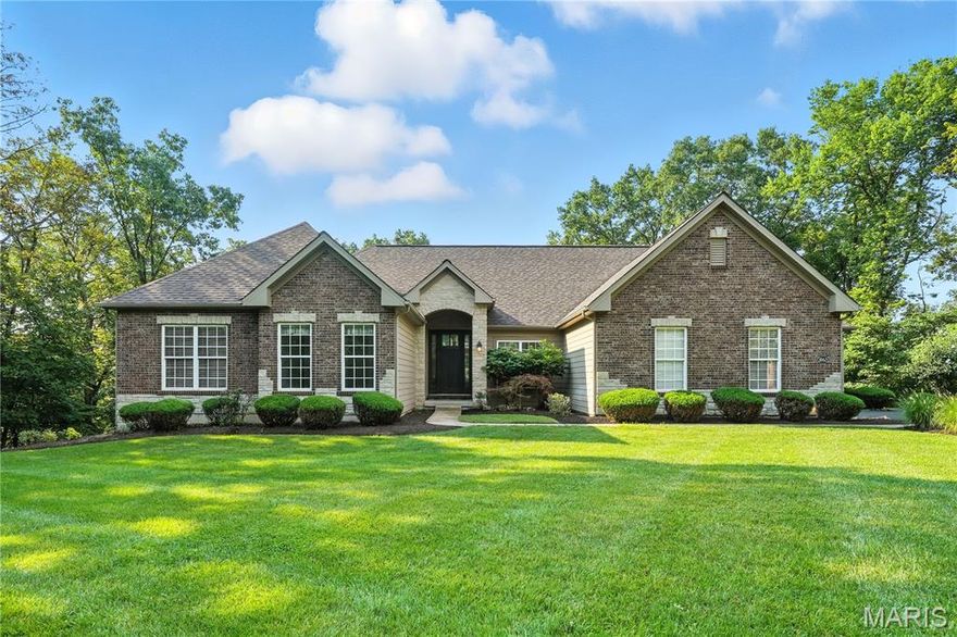 Experience architectural elegance in this thoughtfully designed custom ranch, situated on 4.5 private, wooded acres in Wildwood. With luxury finishes throughout its approx. 4,400 sq. ft. of living space, this home is a showcase of superior craftsmanship. From the moment you arrive, the quality is evident—a full brick front, James Hardie siding, and a distinguished stone-arched header. The interior unfolds with dramatic volume, where gleaming pometia smooth hardwood floors complement the soaring ceilings—including a 12' ceiling in the great room, a 10' tray in the foyer, and a beautifully coffered ceiling in the primary suite. The main floor is an ideal layout for modern living, centered around a gourmet kitchen with a granite island and double wall ovens. Relax by the gas fireplace or on the vaulted 16’x14’ screened porch with composite decking. The main-floor owner's retreat is a luxurious escape, featuring four full-height windows that bathe the space in natural light, and a spa-inspired bath. The finished walkout lower level, with a high 10' pour, offers a massive rec room, wet bar, and a full guest suite. With a 2-year-old roof, smart home technology, and a freshly resurfaced driveway (2025), this impeccably maintained home is truly turn-key. A rare convergence of privacy, luxury, and thoughtful design, all in a prime location near highways, shopping, restaurants, and the Shaw Nature Preserve. Location, size and privacy- one-level living at its absolute best!