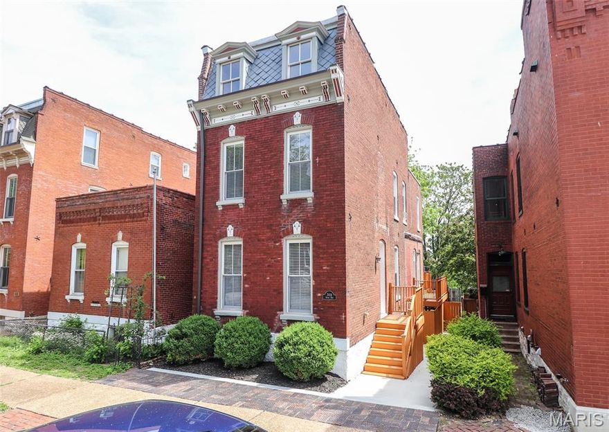 Step into this beautifully renovated 1884 home in the heart of St. Louis’ historic Soulard neighborhood, where thoughtful updates blend seamlessly with timeless architectural character. Rich original hardwood floors, exposed brick, and soaring ceilings create a warm and inviting atmosphere throughout. The main level offers a comfortable living room, a full bath with walk-in shower, a dedicated dining area, and an exceptional kitchen designed to impress. Featuring custom cabinetry, stainless steel appliances, and direct access to a spacious deck, this kitchen is ideal for both everyday living and entertaining. The deck overlooks a level backyard—perfect for outdoor gatherings or quiet mornings with coffee. Upstairs, the second level includes two generously sized bedrooms, an updated full bath with walk-in shower, convenient laundry hookups, and a versatile bonus space ideal for a home office or reading nook. The third floor presents an expansive open area ready for your personal vision. With refinished floors and electrical already in place, this flexible space is perfectly suited for a primary suite, media room, or private retreat. The unfinished basement offers excellent storage and features tall ceilings providing strong potential for future finishing and additional living space. Additional highlights include private off-street parking and an unbeatable location just steps from Soulard’s vibrant shops, restaurants, nightlife, and the iconic Soulard Farmers Market.