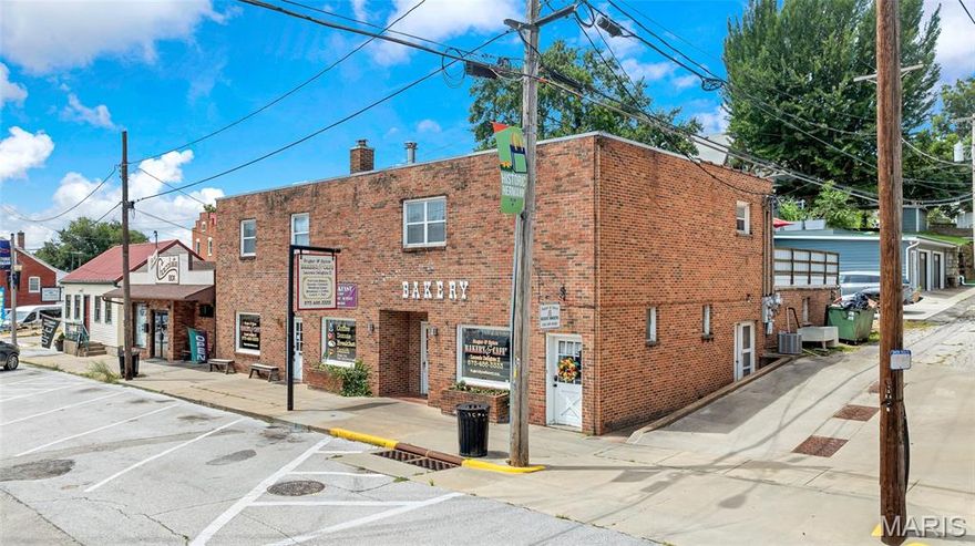 Located in the heart of Hermann’s historic district, this fully updated commercial building offers a rare, turn-key opportunity in one of Missouri’s most popular tourist towns. Previously operated as a beloved bakery, the property features a charming brick facade and a bright, open retail space with high ceilings, large display windows, and modern finishes. An attached dining area— with its own entrance—offers flexibility for expansion, a sub-tenant, or dual-use income. The fully furnished commercial kitchen includes all the essential equipment: fryers, ovens, walk-in cooler, mixers, prep stations, and 3-phase electric—allowing immediate operation. A clean, dry basement provides
extra storage or prep space. Upstairs, a fully renovated 4-bedroom, 1.5-bath residential unit is currently run as a successful Airbnb. It features a private entrance, separate utilities, and full furnishings—perfect for continued rental income or owner’s living quarters.
With its unbeatable location, multiple income streams, and complete renovation, this versatile property is an exceptional investment for entrepreneurs or anyone looking to own a piece of Hermann’s historic charm.