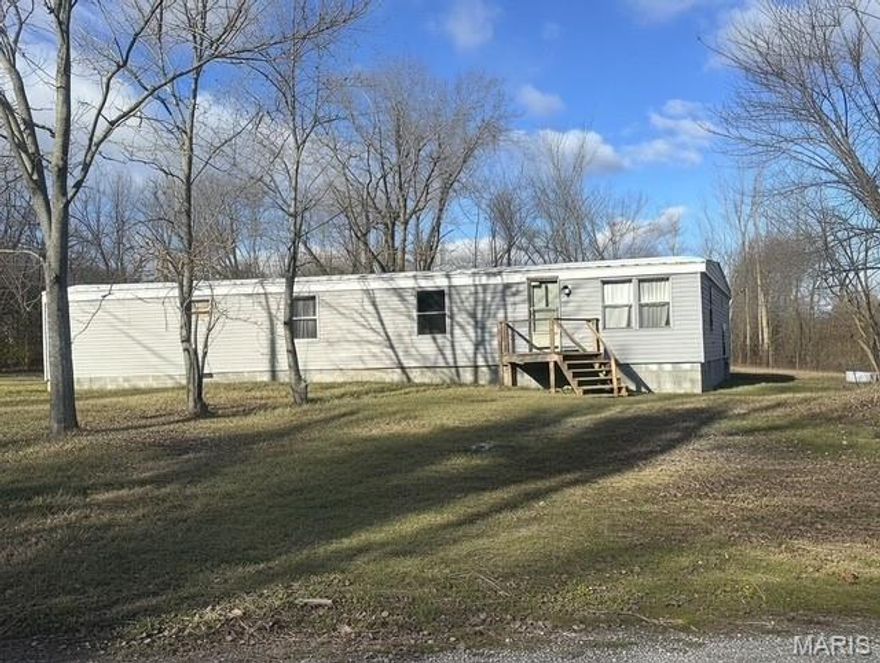 Quiet living in a quiet town. Located at the end of the road it will be like living in the country. This mobile home has 2 nice sized bedrooms and a roomy bathroom. The open kitchen/dining room runs wide open with the living room making the home feel large and comfortable. the home has new floors, plumbing, fixtures, carpet and vinyl, deck and siding, granite sink and new stool and HVAC is only 5 yrs old. Plus it is set on a permanent foundation on an flat 1/2 acre lot.  Very inexpensive living.