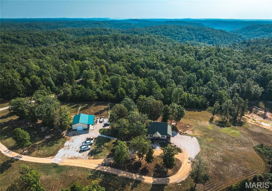 Welcome to this remarkable 5-bed, 4-bath home set on over 12 scenic acres in the heart of the Ozark National Scenic Riverways and Alley Spring. Surrounded by natural beauty & just minutes from rivers, campgrounds & hiking trails, this property offers the perfect blend of outdoor adventure & comfortable living. Inside, you're greeted by an inviting open floor plan that flows seamlessly from room to room. The spacious living area features soaring vaulted ceilings, a stunning fireplace & plenty of natural light, creating a warm and welcoming atmosphere. The home has been thoughtfully updated throughout, featuring engineered wood floors, modern finishes & fresh touches that make it move-in ready. The kitchen & bathrooms have also been updated, providing both style & convenience for everyday living. With 5 bedrooms & 4 full bathrooms, there’s room for everyone to spread out comfortably. Outside, a large, covered deck invites you to relax, unwind & enjoy panoramic views of your pond and rolling hills. Imagine sipping your morning coffee while listening to the sounds of nature, or hosting gatherings with friends & family while taking in the peaceful surroundings. For those who value space for hobbies or work, the property includes a 30x40 shop complete with heating & air conditioning—perfect for projects, storage, or even a home-based business. Additional features include a chicken coop & a dog fence, making the property ideal for those who want to embrace a country lifestyle.