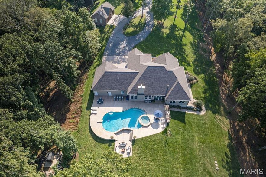 Truly, words cannot capture the breathtaking beauty of this extraordinary home.
Exquisite in every detail, this residence stuns from top to bottom. The grand great room, elegant kitchen, formal dining room, and charming breakfast area flow seamlessly together—designed for effortless entertaining and luxurious everyday living.
Step outside onto the expansive stamped concrete patio, where a built-in in-ground pool and hot tub invite relaxation. Just beyond, gather around the cozy fire pit in a dedicated seating area, perfectly positioned to soak in the panoramic views that stretch across the horizon. Or take a leisurely stroll through the sprawling backyard to a private patio perched above the majestic bluff—offering an awe-inspiring vantage point over the Mississippi River Bottoms.
This is a nature lover’s paradise. Watch eagles soar, deer graze, and an endless variety of wildlife roam—including cranes, blue herons, and so much more.
The main level offers three spacious bedrooms, including a stunning primary suite large enough for a private sitting area and featuring a warm gas log fireplace. The spa-like primary bath exudes elegance beyond words.
Downstairs the expansive lower level offers the ideal setup for in-law quarters, guest accommodations, or an additional entertainment space—complete with a second full kitchen.
And for the car enthusiast or toy collector, the 7 garage space is simply unmatched—room for all your passions and more.