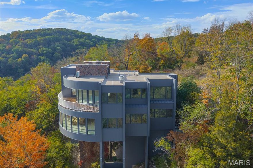 Welcome to a true Ballwin/St. Louis County unicorn! Bring your creative vision to this large, diamond-in-the-rough contemporary property, designed to optimize its million-dollar views overlooking Castlewood State Park. This sale includes 2 structures and 3 separate plots of land totaling 14.61 acres. Tucked away at the furthermost end of the subdivision, and zoned non-urban, this opportunity offers privacy, breathtaking scenery, and unlimited potential.  The main structure is approximately 4557 square feet across 3 levels and includes two fireplaces (one gas and one wood-burning), a commercial fire-irrigation system, and an elevator. 
A second building on the property adds even more possibilities. Peaceful, private, and unlike anything else on the market—this is a one-of-a-kind opportunity to create something truly special in one of Ballwin’s most scenic settings.