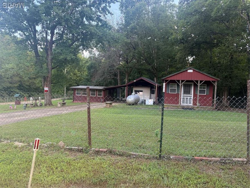 Perefect weekend property located less than an hour out of St. Louis in a gated lake community. Sitting on two lots, just under a half of an acre with a well and a septic. There is a carport with a 2008 Keystone hornet 30’ camper with a slide. Covered parking for a car between camper carport and 16 X 16 summer kitchen type building. An additional 14 X 28 insulated building with electric and a propane wall heater. The lot is park like, with mature trees and offers ample shade for outdoor activities or family gatherings. Great get away or a spot to create your full time home. The 500 gallon propane tank in included with the sale, along with some concrete patio table and benches. There is a wonderful firepit spot, for your bonfire get togethers. Another addititonal building full of shelves for staorage.   See pictures for details and call with any questions.