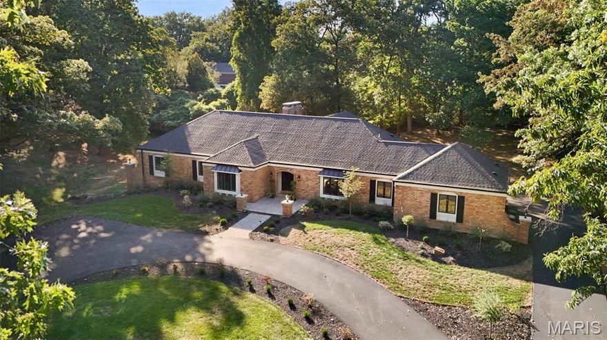 Welcome to 241 South Graeser Road, an exceptional residence within the top-ranked Ladue School District. Completely reimagined and essentially rebuilt in 2022, this home blends modern luxury with timeless design and the privacy of a wooded retreat—while being within 20 minutes of everywhere in St. Louis. Walls, staircases, and entire spaces were moved or rebuilt to create a refined, functional layout, including the relocation of a full bathroom and the main staircase.

The state-of-the-art kitchen is a showpiece featuring one-of-a-kind custom cabinetry, a 5’ x 12’ classic quartz island with an overhang seating six, an oversized Thermador refrigerator with auto-opening doors, Thermador gas cooktop, Bosch double wall oven with side-opening doors, icemaker, and a second prep sink. The butler’s kitchen offers additional custom cabinetry, quartz counters, and another wall oven for effortless entertaining.

The master suite is a private sanctuary highlighted by a gas fireplace with a marble surround and custom mantle, a luxurious marble bath with floors and walls in marble, an extended double-sink custom vanity with a granite top, high-end lighting including automatic under-cabinet illumination, a soaking tub, walk-in shower, and a relocated window for natural light. The boutique-style custom closet features a center island with power and charging stations, and a hidden laundry area adds convenience without sacrificing design.

This home includes four fireplaces: masonry gas fireplaces with floor-to-ceiling stone and custom mantles in the great room and sunroom, a marble-surround gas fireplace in the master suite, and a sleek biofuel fireplace in the Dark Room.

The dining room features a swinging door to the butler’s kitchen and a window seat overlooking the expansive front yard—perfect for everyday meals and holiday celebrations. The Dark Room provides a warm, intimate space with its biofuel fireplace, dramatic lighting, and another inviting window seat. The sunroom impresses with a floor-to-ceiling stone gas fireplace, soaring coffered ceilings, and room for multiple seating or dining areas—ideal for year-round enjoyment.

Every system has been renewed, including all-new wiring, plumbing, and lighting fixtures, plus a new subfloor on the main level. Two new sump pumps with interior drain tile and an exterior French drain, a brand-new 35-year architectural shingle roof, and added attic insulation ensure comfort and efficiency. Exterior upgrades include a new composite deck with hidden walk-up basement access, expanded driveway, new irrigation system, and complete landscaping.

Surrounded by 9 acres of woods and fronted by 5.5 acres more, the setting provides extraordinary privacy, with only one window offering a view toward another residence. Despite its seclusion, the location provides exceptional access to major highways, dining, shopping, hospitals, and top-rated schools. With its comprehensive redesign, impeccable craftsmanship, and serene natural surroundings, 241 South Graeser Road offers a level of luxury and livability that is truly one of a kind.