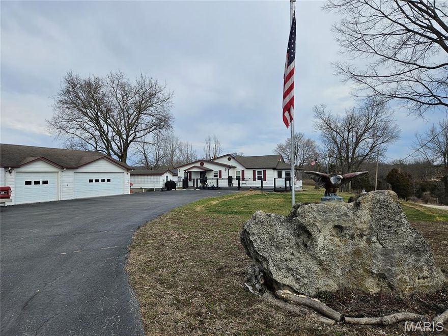 16 acres of usable land with endless potential! This 2 bed, 2 bath home includes washer, dryer, and major appliances that will convey. Property also features a 4-car garage, sunroom with beautiful views, composite deck, storm shelter, well house, and a Generac propane whole-home generator for added peace of mind. Security is covered with an ADT system including door alarms and glass break sensors (buyer will need to provide service). The property includes three ponds (two stocked), the middle pond boasts a covered dock, perfect area for parties, picnics or relaxing evenings watching the sunset. Raised garden beds, rain barrels at the gutters, and a driveway that runs through the acreage, providing easy access for future expansion or additional structures. Suitable for farm animals (not currently fenced). Ideal for a hobby farm, recreation, or those seeking space, privacy, and room to grow.