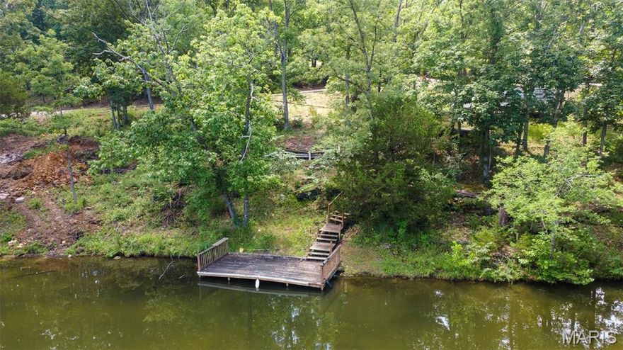 Enjoy lakefront living on this spacious .64 acre double lot at beautiful Lake Perry! With approximately 210 feet of water frontage, this versatile property is perfect for permanent camping, weekend getaways, or even building your dream lake home. A circle driveway provides easy access, and the lot is already equipped with two water hookups, one sewer connection, and a 2003 Layton camper that sleeps six—making it ready for immediate use. Unwind in nature with your own wooden dock, accessible by staircase, where you can fish, swim, boat, or simply relax by the water. A garden shed offers extra storage for lake gear and tools. Whether you want to keep it simple or build a custom retreat, this property offers plenty of possibilities. Currently platted as one parcel, the lot can be split back into two if desired, offering future flexibility. Located in a gated lake community, residents enjoy amenities such as a seasonal pool and restaurant, sandy beaches, volleyball courts, a playground, and shower/laundry facilities. Conveniently located within driving distance from Cape Girardeau and St. Louis, Lake Perry is the ideal place to make lasting memories.