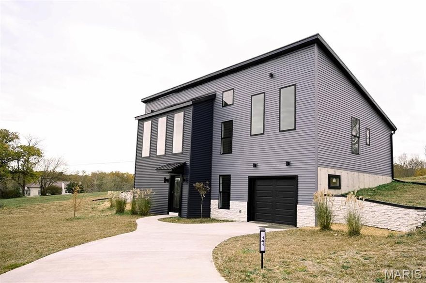 Be the first to live in this one of kind home 3 bed 3 bath in Bourbon Mo, both contemporary and modern with a lot of storage. This home sits on 1+ ac, with a lot of room to add a workshop or other out buildings. Front of home feature large windows looking over the rolling property. Main level entry from rear of home, with open concept for kitchen, dining and living room. Upgraded kitchen with quartz countertops, 6 burner gas range, upgraded SMART appliances. Upgraded kitchen cabinets with soft close features Large quartz bar with seating. Kitchen offers a large pantry. Seller is offering $1,000 at closing for buyer to purchase materials to finish pantry and bedroom closets to their preference.
Lower level is ground level entry at the front of the house, and features interior entry to garage, a large finished family room, a third bedroom and third full bath. This home has a lot of extras, schedule a tour before it is too late.