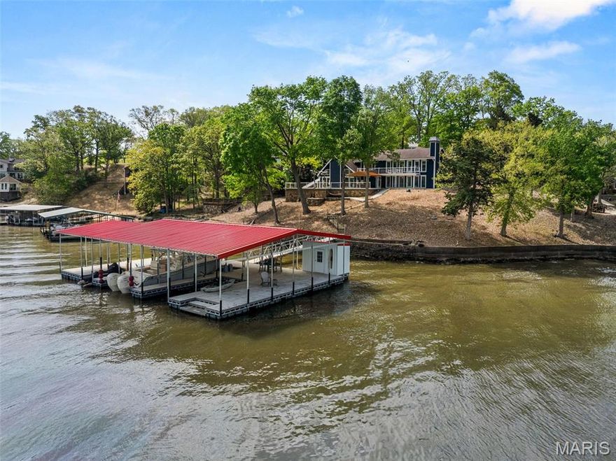 Spectacular lakefront retreat at MM 47 in Sunset Shores, Climax Springs! This beautifully remodeled 3BR/2.5BA home offers 120 ft of sea-walled shoreline with stunning panoramic views. Designed for entertaining, it features an open floor plan, vaulted tongue-and-groove ceilings, quartz kitchen countertops, custom cabinetry, SS appliances, and a spacious island. Stylishly furnished with new LVP flooring, paint, blinds, lighting, fans, and a cozy wet bar. The master suite and two guest BRs with Jack-and-Jill bath offer comfort, while a family room adds flexibility. Outdoor highlights include new Trex decking, a covered deck, outdoor shower, and a brand-new 2-well concrete dock (2023) with 14x36 and 10x24 slips, PWC slip, 20,000lb hoist, dock locker, and martini deck. Also includes a 2-car garage, ample parking, community water, and ramp access. A move-in-ready lakefront gem perfect for lake life!