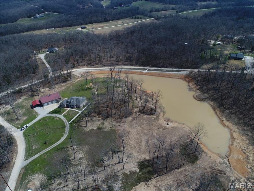 Beautiful home on 10.7 acres in a fantastic location just outside of town with convenient access to Sullivan. The property features a large newly constructed lake, offering a peaceful setting and excellent outdoor recreation opportunities. The home offers 3 bedrooms and 2 bathrooms on the main level with an open concept layout. The kitchen features stainless steel appliances, center island, breakfast nook, and tile flooring, while LVP flooring runs throughout the rest of the main level. The spacious master suite includes a jetted tub, separate shower, large walk-in closet, and private access to the covered back patio. Additional main level features include a mudroom/laundry room and attached 2-car garage. The front exterior showcases a classic all-brick facade. The walkout basement includes a finished sleeping room or office, full bathroom, and abundant storage, with the remaining space nearly finished and only flooring needed. For those needing workspace or storage, the property includes a 40x60 fully insulated metal shop with concrete floors, three 10' automatic garage doors, 12' sidewalls, 13'+ center height, and its own 200 amp electrical panel. A three-sided carport provides additional covered parking or equipment storage. Major updates include a new roof and gutters in 2025 and a HVAC system that is only 3 years old. A rare opportunity to own a well-maintained home with acreage, a large shop, and a brand new lake in a highly desirable location.