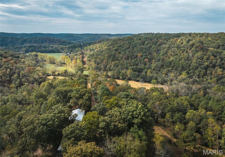Welcome to your private Ozark retreat—244 acres of rolling hills, open fields, and abundant wildlife in the heart of southern Missouri. This beautiful property offers a perfect blend of seclusion and functionality, featuring five open fields ideal for future food plots and two ponds that provide water for wildlife or could easily be stocked for fishing. Property also features 5 tripod deer stands, making this a sportsman’s paradise. The spacious 3-bedroom, 3-bath home offers approximately 2,100 sq. ft. of comfortable living space with beautiful wood floors and a classic brick exterior. Enjoy peaceful mornings in the 248 sq. ft. enclosed sunroom or relax on the 276 sq. ft. back deck overlooking the property’s scenic landscape. A cozy fireplace and wood shed make it easy to enjoy wood heat on cool Ozark nights, while a 45 kW whole-home Generac generator ensures power year-round. Additional features include an attached 2-car garage, a 30x40 pole barn with electric, a carport, a 15x15 utility or garden shed, and an 8x24 garden shed. Little Gladden Creek winds through the property as a wet-weather creek—a fun place to explore, hunt for arrowheads, or simply enjoy the natural beauty. Located just 12 miles from the famed Current River, known for trout fishing, and minutes from the 160-acre Cedar Grove Conservation Area, this property is ideal for anyone seeking a serene country lifestyle with endless outdoor recreation right at their doorstep.