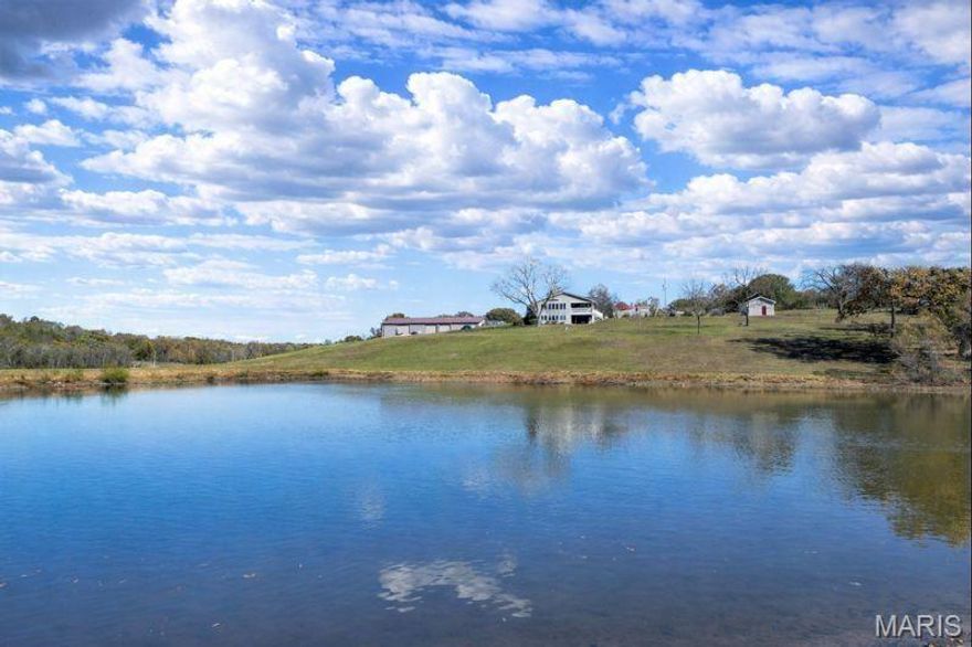 Charming 27+ Acre Historic Farmstead with Income Potential and Scenic Views. Welcome to this exceptional farmstead where historic character and modern comforts blend beautifully. The original portion of the main home dates back to the late 1800s, with the preserved hand-hewn logs now showcased as a stunning interior feature. Over the years, the home has been expanded and fully bricked, offering the perfect mix of old-world charm and updated living spaces.Inside, the central hallway greets you with exposed beams and timeless craftsmanship. To one side, a spacious formal dining room offers a warm setting for gatherings, while the opposite side features a large living room with a fireplace—both rooms highlighting the original logs, beam ceilings, and clear pine floors.
At the end of the hallway, the kitchen is a true centerpiece with custom wood cabinetry and oak countertops made from reclaimed barn wood. Premium stainless steel appliances include a Wolf 6-burner gas stove with double ovens. Adjacent spaces include a large family room and a sunroom that overlook the picturesque property. The lower level is designed for entertaining, featuring a generous recreation room, a hot tub area, and a convenient tuck-under garage. Outside, enjoy a large in-ground gunite pool and pool house awaiting your finishing touches. Additional highlights include two established turn-key short-term rental units that provide a steady income stream, a substantial barn with parking for six or more vehicles, and a large workshop area originally designed for heavy equipment. The rear portion of the barn offers potential for horse stalls, and the open pastures are ideal for livestock or equestrian use. The property also includes a beautiful stocked 1-acre pond and a recent survey showing potential for an additional homesite. This remarkable property offers endless possibilities—whether as a private retreat, working farm, or investment opportunity—all within a serene, scenic setting.