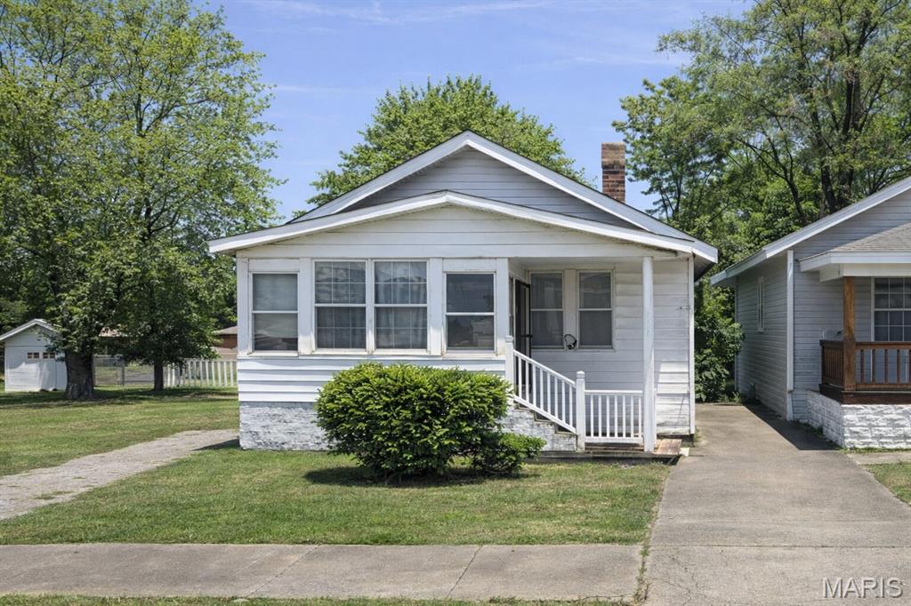 View of front of home featuring a chimney and a porch