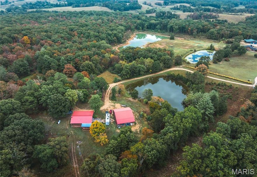 Welcome to The Cabin at Bucks Acres, a custom 3-bedroom, 2-bath, 1,680 sq. ft. retreat nestled on 13.5 park-like acres in the heart of Missouri’s floating capital. This property is a true outdoorsman’s paradise, offering both seclusion and convenience, just 10 minutes from Steelville and its famed rivers—the Courtois, Huzzah, and nearby Meramec. The centerpiece of the property is a beautiful 1-acre stocked pond, complete with a floating dock and bench for peaceful afternoons of fishing and relaxation. A second pond doubles as a prime watering hole and an excellent bow-hunting location. Wildlife abounds here, with frequent sightings of deer, turkey, squirrels, and rabbits. The cabin is built to last with a durable metal roof and a warm, rustic interior accented by wood walls. A spacious basement features a large bedroom, full bathroom, and private walkout, perfect for guests or extended family. Outdoors, a trail system winds through the acreage for hiking or ATV riding, while the 40x40 insulated pole barn with concrete floors and electricity provides ample space for storage, hobbies, or a workshop. Set privately at the end of an easement road with minimal neighbors, this property combines seclusion with accessibility. Whether you’re looking for a full-time residence, a family getaway, or a sportsman’s basecamp, The Cabin at Bucks Acres offers it all—just an hour and a half from St. Louis.